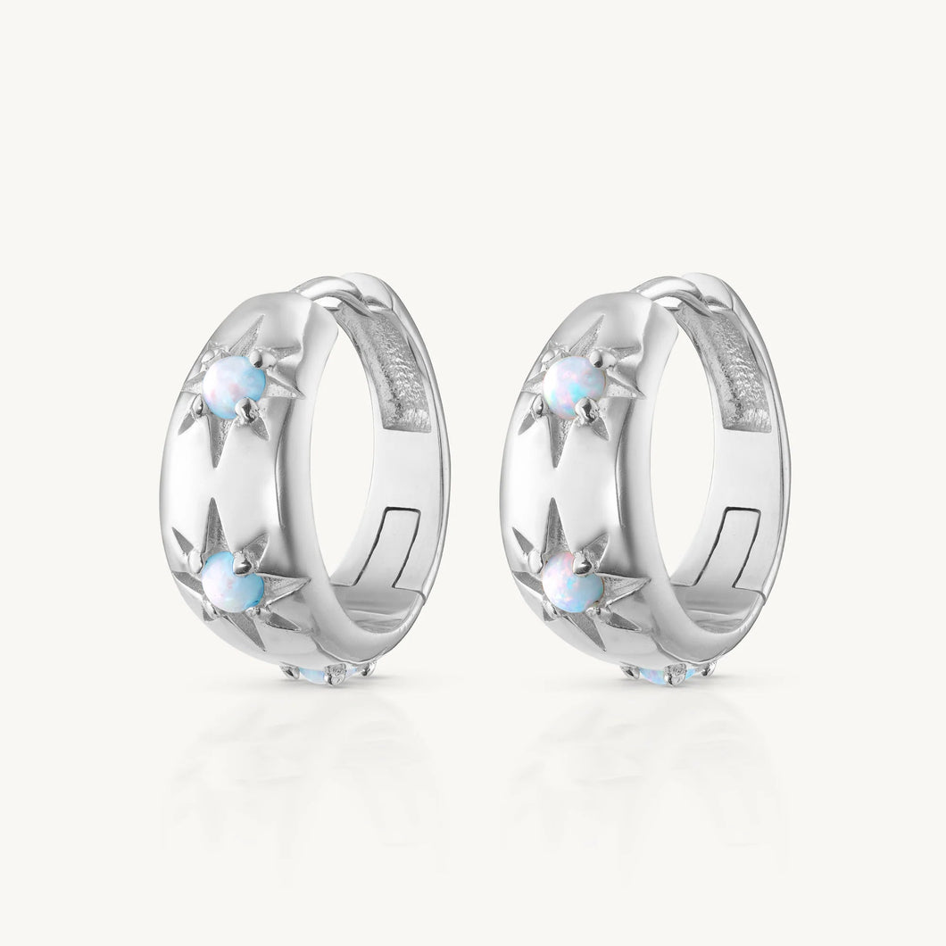 Pair of silver hoop earrings with small stones on a white background