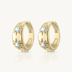 Pair of gold hoop earrings with small stones on a white background