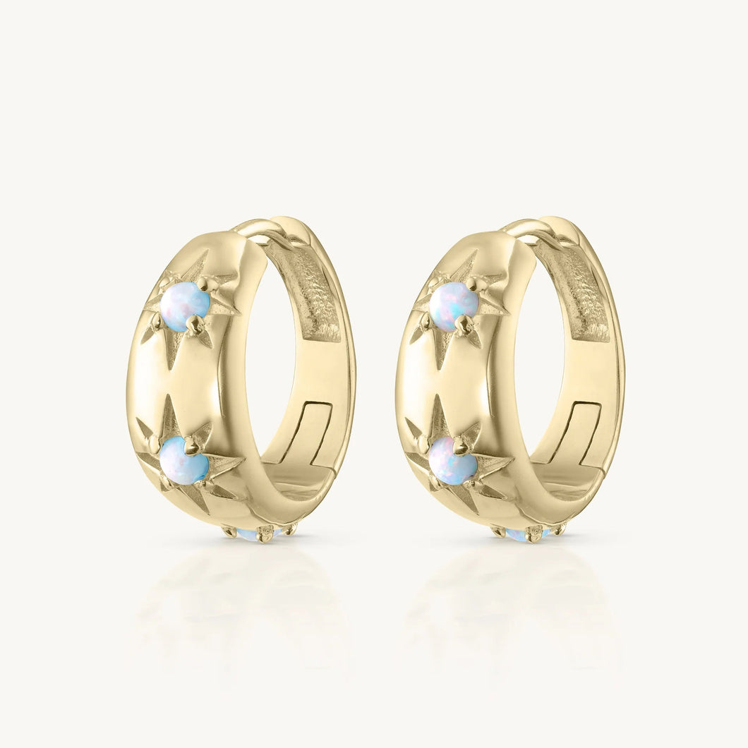 Pair of gold hoop earrings with small stones on a white background
