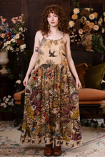 Load image into Gallery viewer, Woman wearing a floral dress standing in a room with floral arrangements.