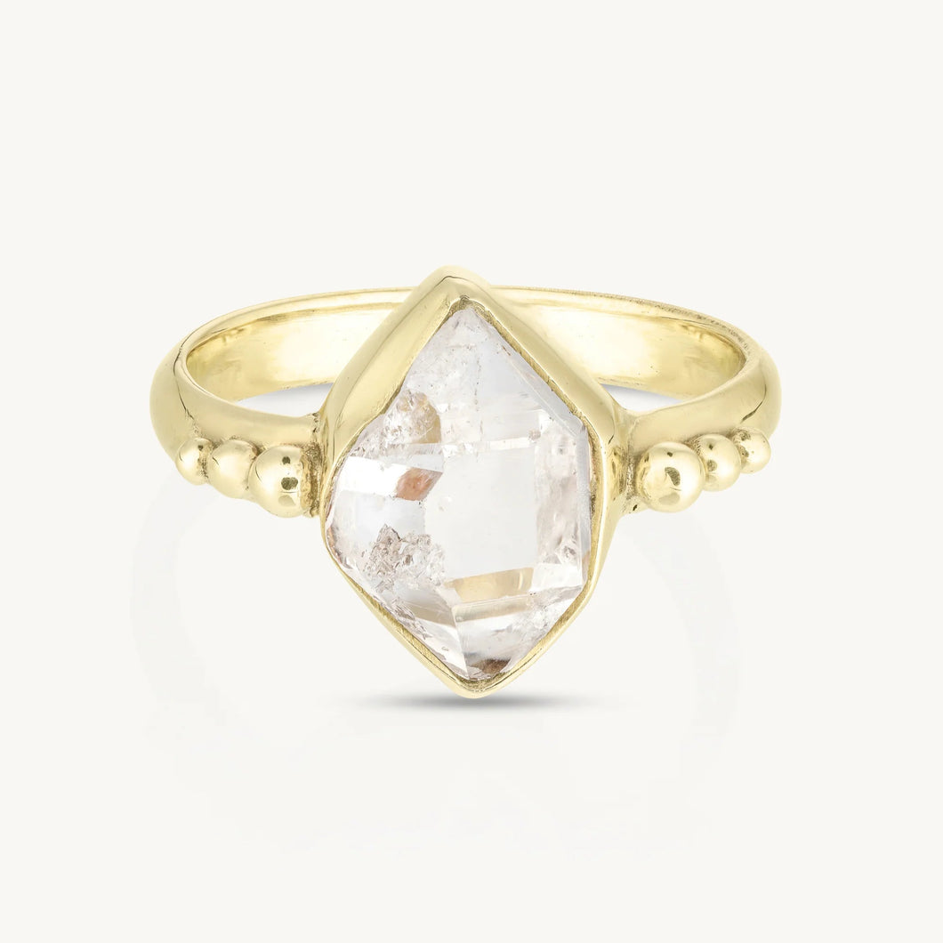 Gold ring with a clear gemstone on a white background