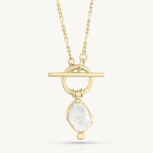 Gold necklace with a pendant featuring a clear gemstone on a white background