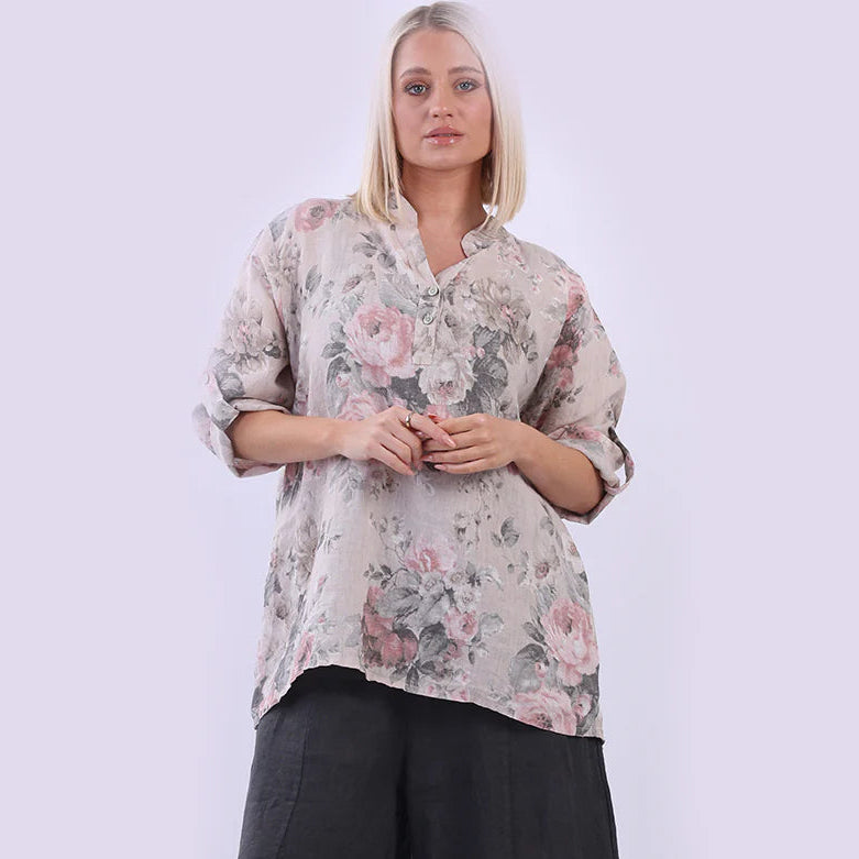 Woman wearing a floral blouse and black pants on a white background
