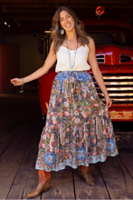 Load image into Gallery viewer, Woman in a floral skirt standing in front of an old red truck.