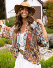 Load image into Gallery viewer, Woman wearing a colourful patterned kimono shirt and white pants outdoors.