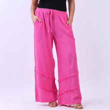 Load image into Gallery viewer, Woman wearing a black sleeveless top and bright pink pants on a white background
