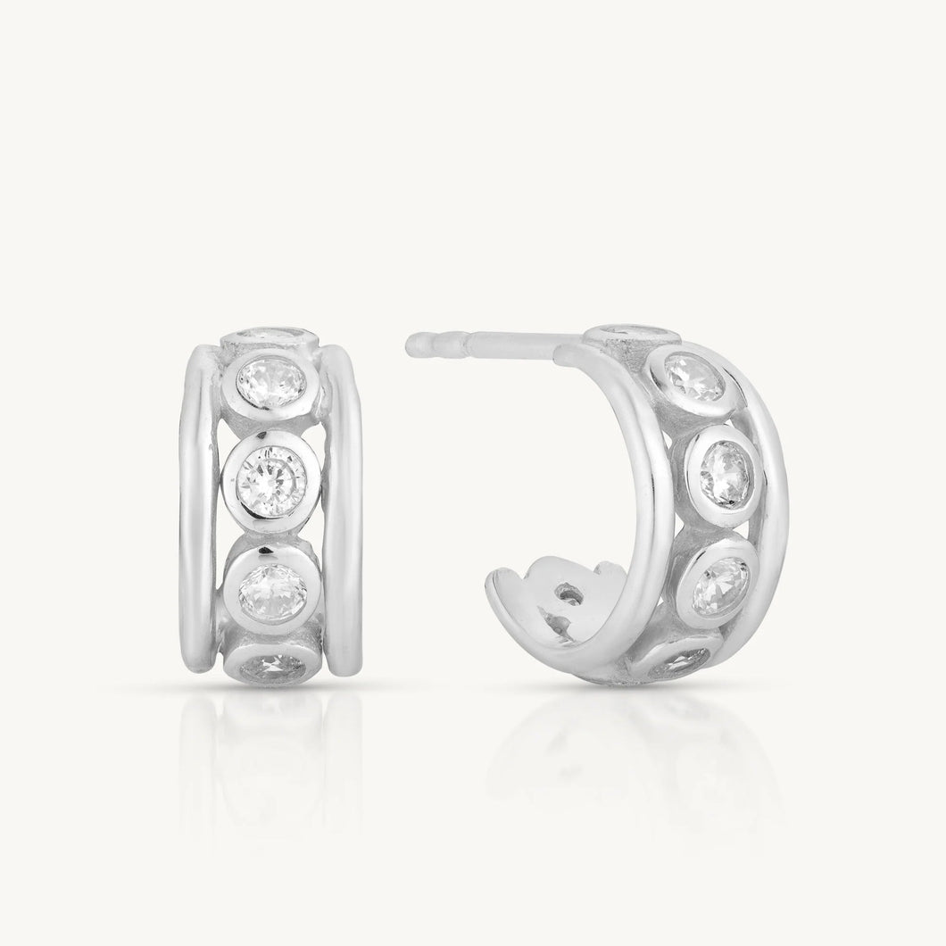 Silver hoop earrings with embedded stones on a white background