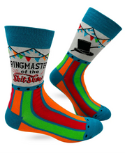 Load image into Gallery viewer, A pair of crew socks with a colorful striped design in teal, orange, green, and red, featuring a white section with a black top hat graphic and bunting, and the text 'RINGMASTER of the Shit Show' on the leg.