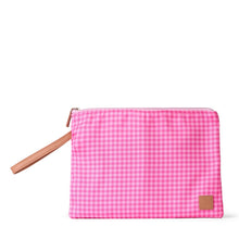 Load image into Gallery viewer, A pink and white gingham zippered pouch with a tan wristlet strap and a small tan brand patch on the bottom right, set against a plain white background.