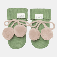 Load image into Gallery viewer, Pair of green baby booties with beige pom-poms on a white background, featuring the brand 'toshi'.