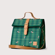 Load image into Gallery viewer, A green plaid lunch bag with a bee pattern, tan leather strap and buckle, and a top handle, shown on a light gray background.