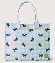 Load image into Gallery viewer, A light blue and yellow gingham tote bag with a repeating pattern of black and green butterflies, featuring light blue handles and a small green brand patch on the bottom right.