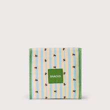 Load image into Gallery viewer, A square fabric snack box with a striped pattern of light blue and cream vertical stripes, decorated with small black and yellow bumblebees. A green square patch on the front reads 'SNACKS' in white text.
